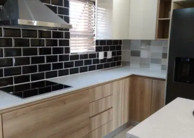 Wood-look kitchen with a black subway tile splashback