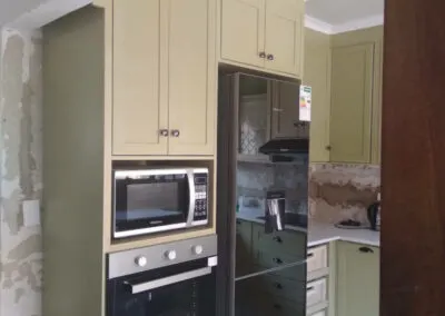 Close-up of sage green kitchen cabinets with a gloss finish