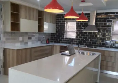 Wood-look kitchen island under red pendant lights