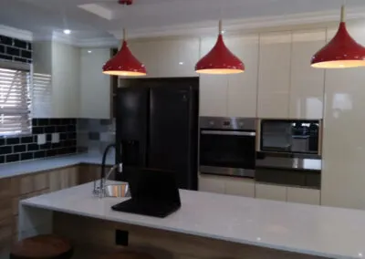 Cream high-gloss kitchen with island and pendant lighting